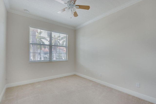 carpeted spare room featuring crown molding and ceiling fan