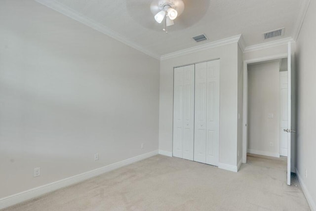 unfurnished bedroom with light colored carpet, a closet, ornamental molding, and ceiling fan