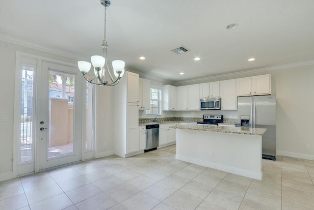 kitchen with appliances with stainless steel finishes, a notable chandelier, white cabinets, light stone counters, and pendant lighting