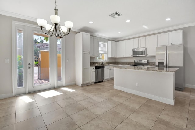 kitchen with plenty of natural light, stainless steel appliances, pendant lighting, and a chandelier