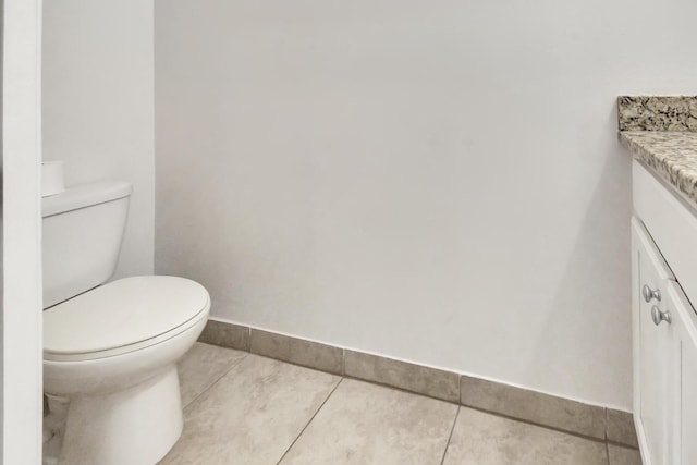 bathroom with tile floors, toilet, and vanity