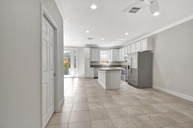 kitchen featuring a center island, light tile flooring, ceiling fan, white cabinetry, and stainless steel fridge