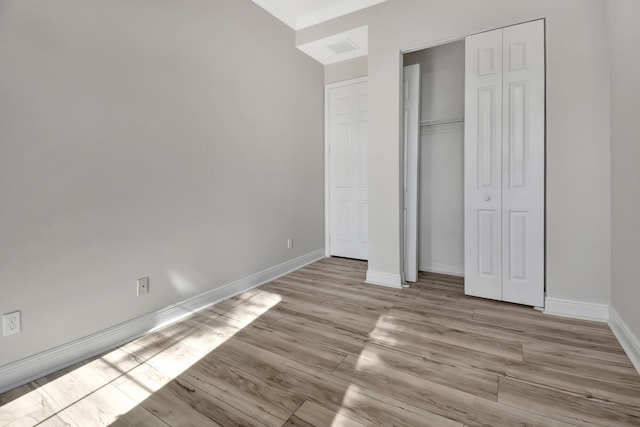 unfurnished bedroom with a closet and light wood-type flooring