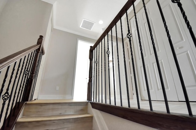 staircase featuring ornamental molding and light wood-type flooring