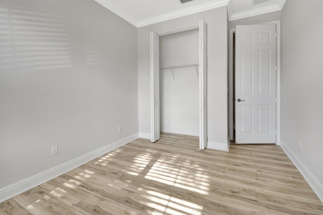 unfurnished bedroom with a closet, light wood-type flooring, and crown molding