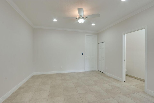 spare room featuring light tile flooring, ornamental molding, and ceiling fan