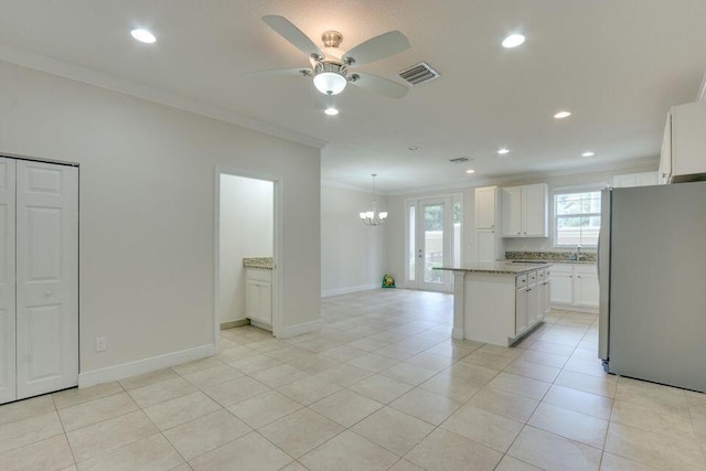 kitchen featuring a kitchen island, ceiling fan with notable chandelier, stainless steel fridge, and white cabinetry