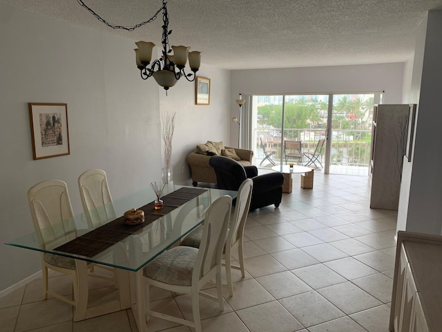 tiled dining area featuring a notable chandelier and a textured ceiling