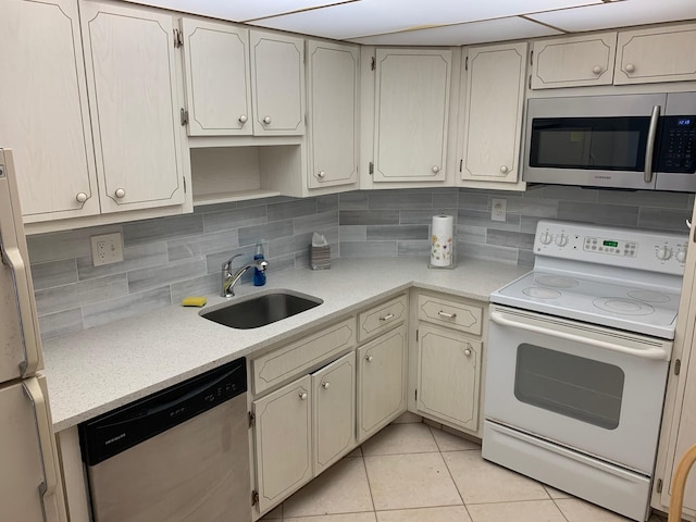 kitchen featuring light tile flooring, tasteful backsplash, sink, and stainless steel appliances