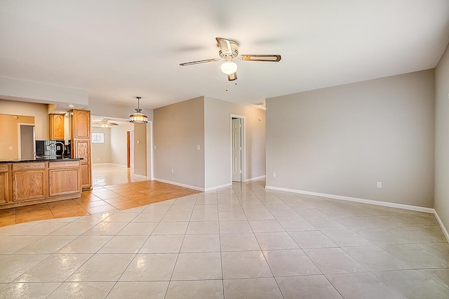 unfurnished living room featuring ceiling fan and light tile floors