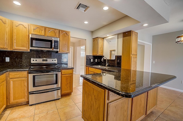 kitchen with tasteful backsplash, stainless steel appliances, and light tile floors