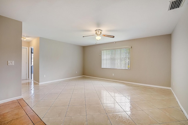 tiled empty room featuring ceiling fan