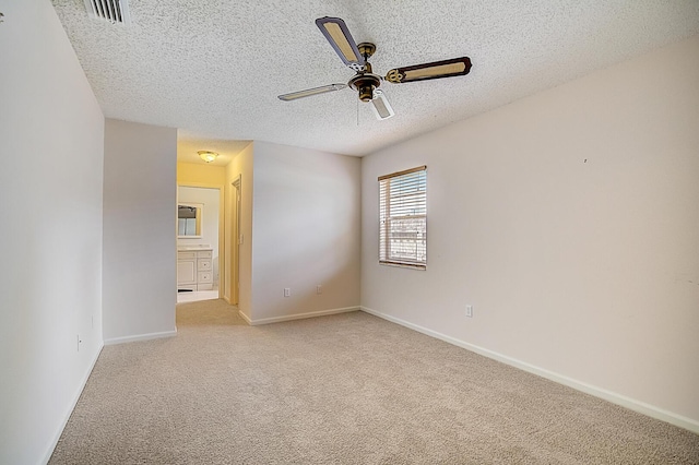 unfurnished bedroom with light carpet, a textured ceiling, and ceiling fan