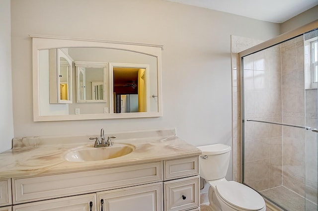 bathroom with an enclosed shower, large vanity, and toilet