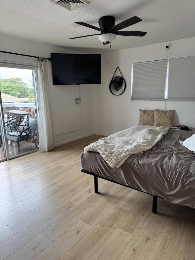 bedroom with access to outside, light wood-type flooring, baseboards, a ceiling fan, and a textured ceiling