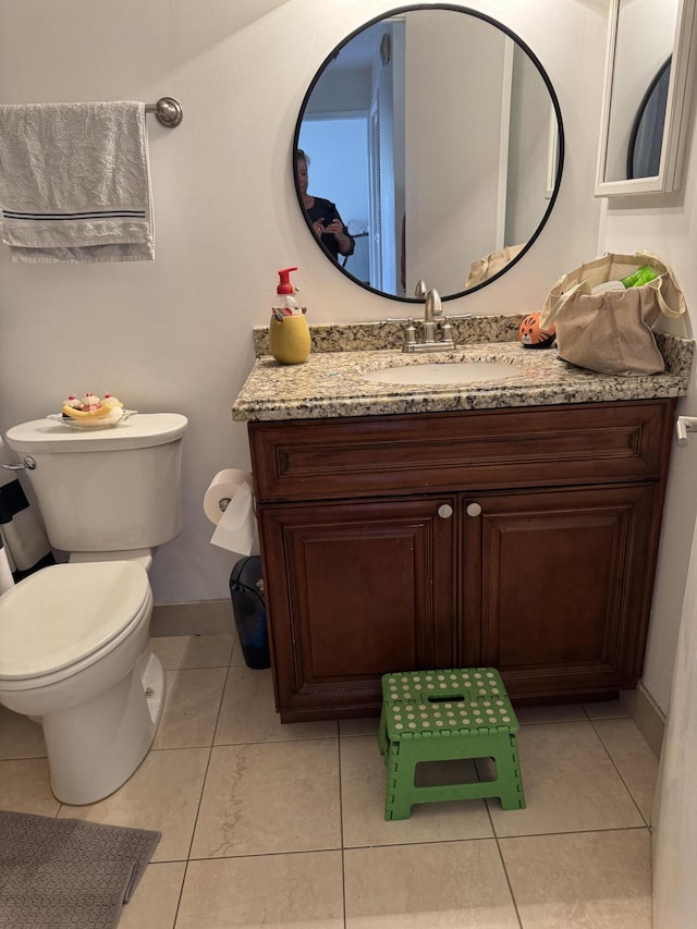 bathroom featuring toilet, baseboards, vanity, and tile patterned floors