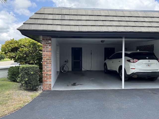 garage with a carport and asphalt driveway