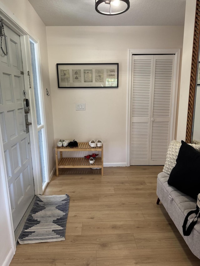 foyer entrance featuring light wood-style flooring and baseboards