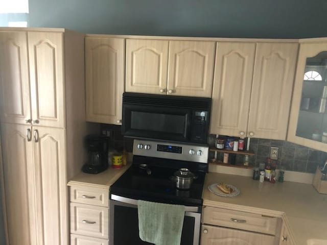 kitchen with stainless steel range with electric stovetop and tasteful backsplash