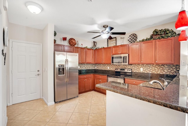 kitchen featuring ceiling fan, sink, stainless steel appliances, tasteful backsplash, and decorative light fixtures