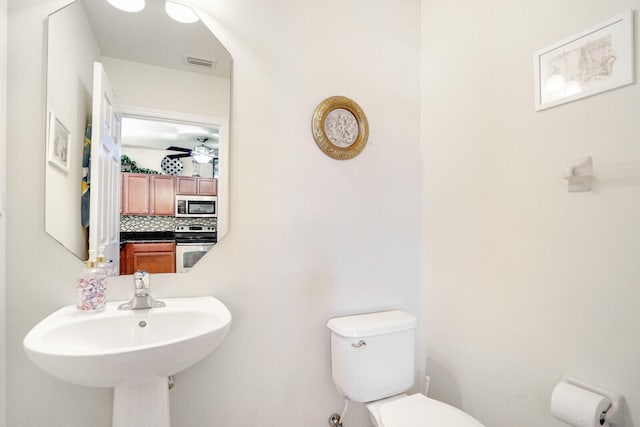 bathroom with tasteful backsplash, ceiling fan, and toilet