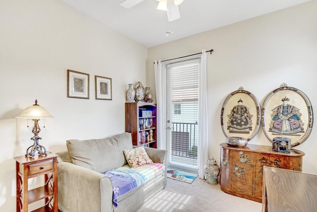 living area featuring light colored carpet and ceiling fan