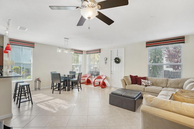 tiled living room featuring a healthy amount of sunlight and ceiling fan