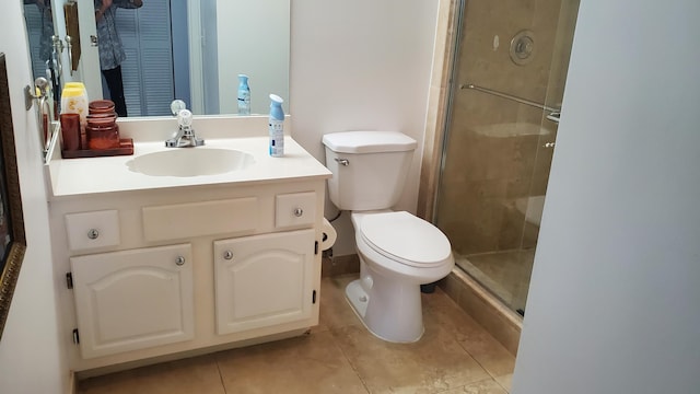 bathroom featuring vanity, tile flooring, toilet, and walk in shower