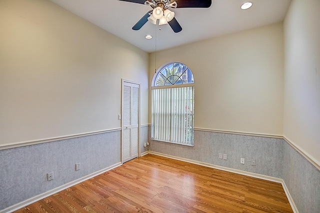 empty room with ceiling fan and light hardwood / wood-style flooring