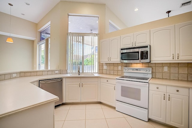 kitchen featuring stainless steel appliances, light tile floors, decorative light fixtures, tasteful backsplash, and white cabinetry