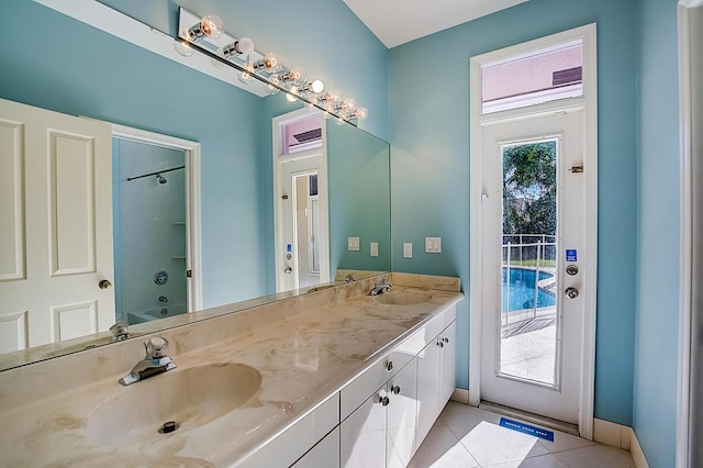 bathroom with tile floors, double sink, vanity with extensive cabinet space, and bathtub / shower combination