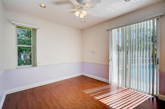 unfurnished room with dark wood-type flooring, ceiling fan, and a wealth of natural light