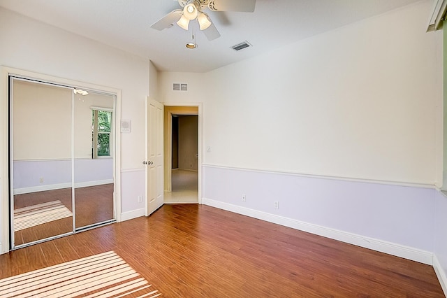 unfurnished bedroom with a closet, ceiling fan, and dark hardwood / wood-style flooring