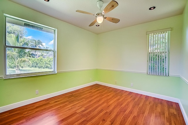 empty room with hardwood / wood-style floors and ceiling fan