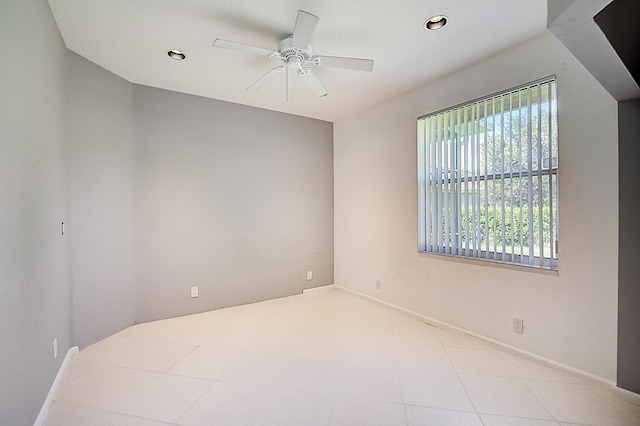 tiled spare room with ceiling fan