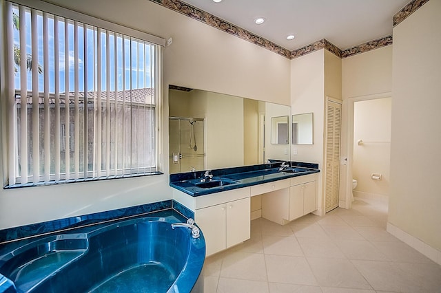 full bathroom with toilet, tile floors, double sink vanity, and independent shower and bath