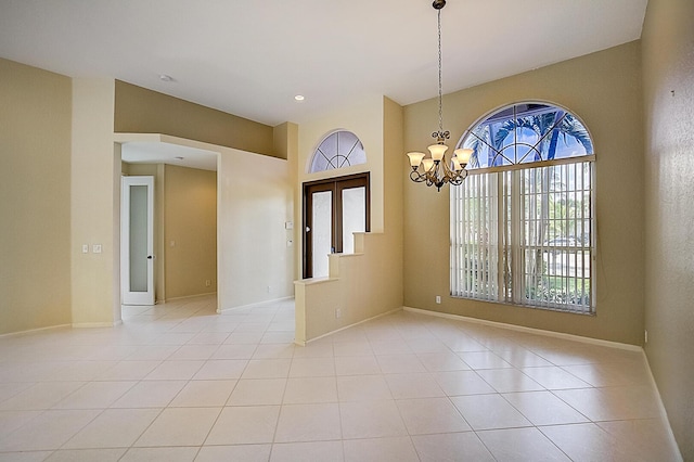 spare room with light tile floors and a notable chandelier