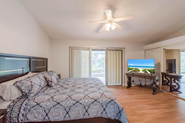 bedroom featuring ceiling fan, access to outside, light hardwood / wood-style flooring, and a textured ceiling