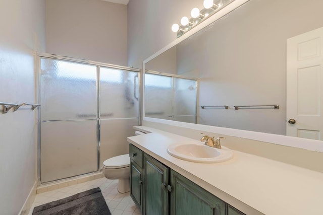 bathroom featuring tile floors, oversized vanity, a shower with shower door, and toilet