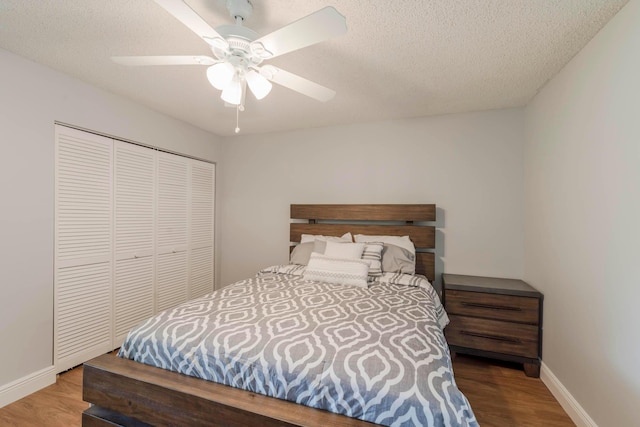 bedroom featuring a closet, a textured ceiling, ceiling fan, and dark hardwood / wood-style flooring