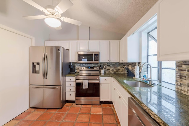 kitchen featuring light tile floors, ceiling fan, appliances with stainless steel finishes, white cabinetry, and backsplash