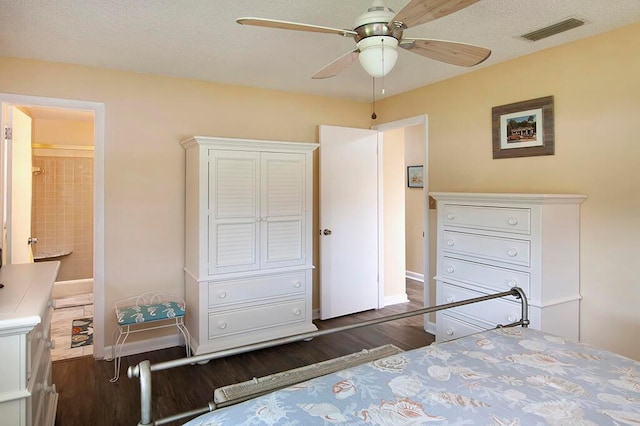 bedroom with connected bathroom, a textured ceiling, dark hardwood / wood-style floors, and ceiling fan