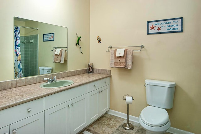 bathroom with toilet, large vanity, and tile flooring