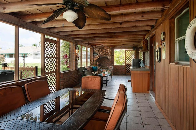 sunroom / solarium with ceiling fan, wooden ceiling, and beamed ceiling