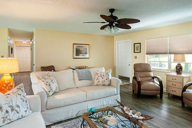 living room with dark hardwood / wood-style flooring, a textured ceiling, and ceiling fan