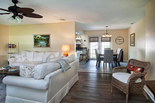 living room featuring french doors, a textured ceiling, dark hardwood / wood-style floors, and ceiling fan with notable chandelier