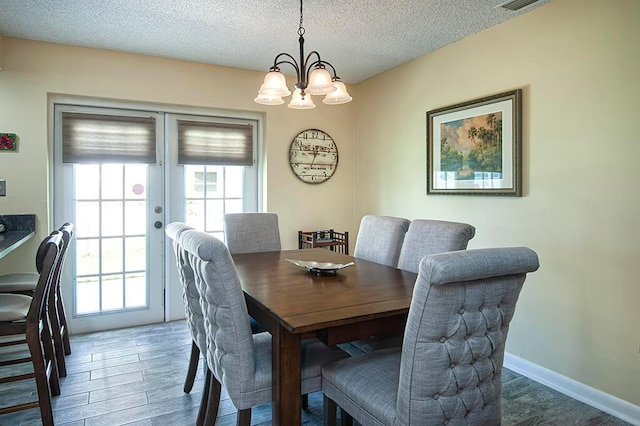 dining space with a textured ceiling, a notable chandelier, dark hardwood / wood-style floors, and a wealth of natural light