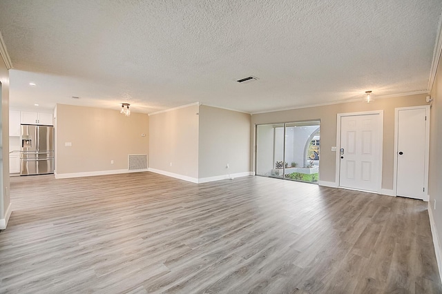 unfurnished living room with light hardwood / wood-style floors, ornamental molding, and a textured ceiling