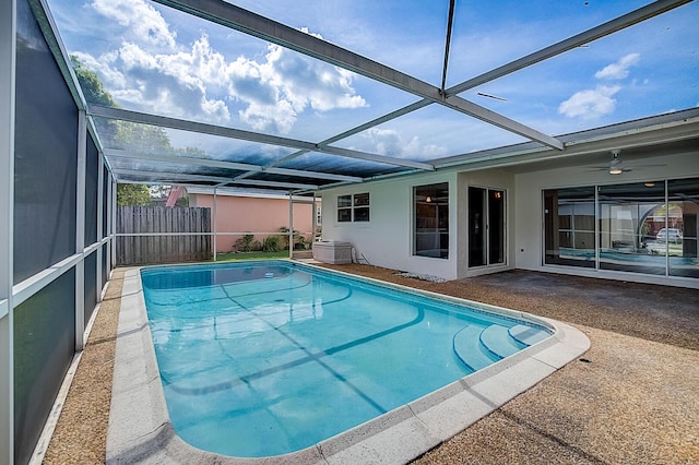 view of pool with glass enclosure and a patio area