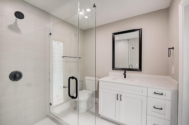 bathroom with vanity, walk in shower, tile flooring, and toilet